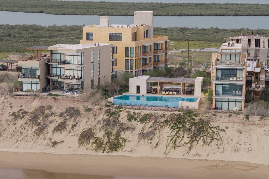 Vista aérea de los condominios de Punta Península sobre la duna, con alberca y la playa al frente